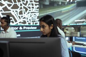 Indian employee following delivery trucks in traffic via mobile map with gps tracking, monitoring location and destination to ensure parcel shipment. Woman uses public surveillance cameras. photo