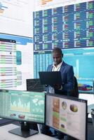 General director CEO sharing insight about a new development strategy with his employees, showing important data reports to analyze organizational activity status in a control room. photo