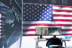 Empty army command center with big data presents the American flag, top secret armed forces agency protecting the country from threats. Monitoring room with high tech gear. photo