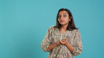 Portrait of envious indian woman mockingly clapping hands, showing frustration, studio backdrop. Resentful sassy person rolling eyes and applauding in jest, feeling irritated, camera A photo