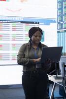 Chief financial officer studying capital funds and revenue data on big screen and laptop, verifying annual reports and budget allocation for a project. Looking for ways to increase profit. photo