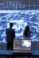 Focus on complex AI brain models being analyzed on laptop by developers in blurry background. Close up of machine learning on notebook used by teamworking IT staff members to develop AI photo