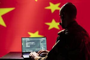Chinese army telecommunication systems operator using radio and satellite tech, talking in headphones mic. China military dispatcher managing communications networks, typing on device photo