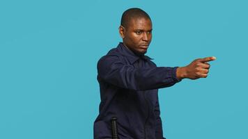 Security guard pointing finger at people to prevent them from gaining access in restricted areas. Portrait of stern bodyguard scolding and telling off unwanted visitors, studio background, camera A photo