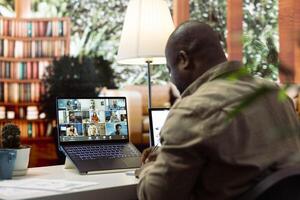 Entrepreneur reviewing sales data and market trends with shareholders on an online videoconference call, focusing on profit growth and stock exchange opportunities at his house. photo