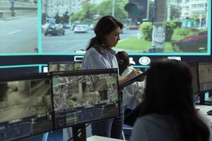 Supervisor gathering intelligence from radar based surveillance footage, team of operators analyzing traffic through CCTV security system. Control center plate recognition activity. photo