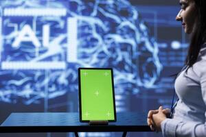 Engineer uses AI machine learning to extract information from complex data on green screen tablet. Woman in workspace uses artificial intelligence technology on mockup device, close up photo