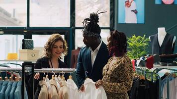 African american worker assisting pregnant woman to buy comfortable clothes, searching colorful pregnancy items from the new fashion collection. Employee talking to client in store. Camera A. photo