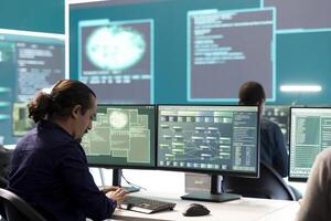 Professional IT expert working in a governmental security operations center, analyzing data on a big screen. Highlighting the importance of cyber security monitoring and threat analysis. photo