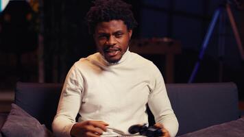 Portrait of BIPOC gamer feeling happy after receiving winner screen on gaming console for killing all enemies. Close up shot of delighted player at home bragging after being victorious in videogame photo