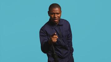 Security guard pointing finger, scolding people for trespassing on private property. Portrait of stern bodyguard berating unwanted visitors for entering restricted area, studio background, camera B photo