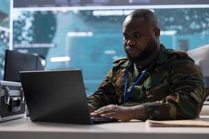 Army officer employs high tech computer in a control tower power base, including surveillance radar imagery and satellite systems. Expert supporting military operations against potential threats. photo
