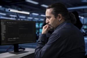 Computer scientist doing maintenance in server room to extend equipment life span and avoid downtime. IT professional monitoring rackmounts for overheating problems and power fluctuations photo