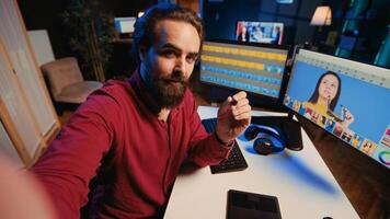 Photo editor using cellphone selfie camera to film tutorial on how to polish raw footage and apply modern editing techniques. Photographer recording internet guide on professionally adjusting images