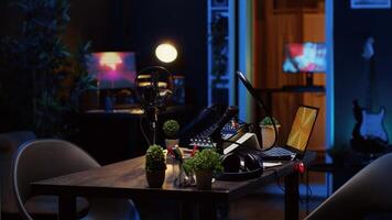 Panning shot of empty personal studio with high tech microphone, audio mixer and headphones used to record podcast. Livestreaming professional gear and 3D renders running on monitors photo