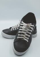 shoe sneaker on white background, close up of sneaker on white background, old black generic sneakers on white background. photo