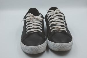 shoe sneaker on white background, close up of sneaker on white background, old black generic sneakers on white background. photo