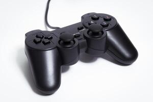 Black controller on white background, game device, Joystick on a white background. photo