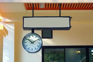 Signs with the name of the train station and antique clocks that hung in the train station in the past to tell the time photo