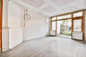 An empty room with a window and a fireplace photo