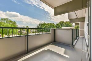 A balcony with a railing and a view of trees photo