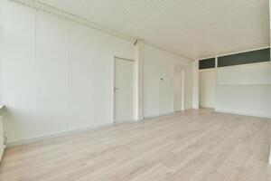 An empty room with wooden floors and white walls photo