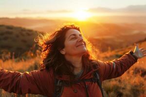 Peaceful woman facing the horizon with arms open wide during sunset photo