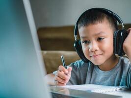 Online education, Technology studying at home using laptop computer, Student distance learning virtual distance online class on call virtual lesson, Teaching child boy with remote education. photo