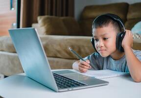 Online education, Technology studying at home using laptop computer, Student distance learning virtual distance online class on call virtual lesson, Teaching child boy with remote education. photo