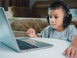Online education, Technology studying at home using laptop computer, Student distance learning virtual distance online class on call virtual lesson, Teaching child boy with remote education. photo