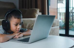 Online education, Technology studying at home using laptop computer, Student distance learning virtual distance online class on call virtual lesson, Teaching child boy with remote education. photo