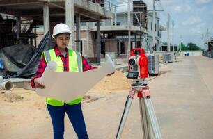Engineers holding blueprint project working outdoors building side with blueprints on a worksite, Engineering and architecture concept, Engineer working at site of a large building project. photo
