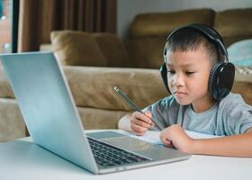 Online education, Technology studying at home using laptop computer, Student distance learning virtual distance online class on call virtual lesson, Teaching child boy with remote education. photo