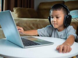 Online education, Technology studying at home using laptop computer, Student distance learning virtual distance online class on call virtual lesson, Teaching child boy with remote education. photo