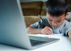 Technology studying at home using laptop computer, Student distance learning virtual distance online class on call virtual lesson, Parent or tutor teaching child boy with remote education. photo