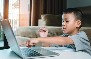 Technology studying at home using laptop computer, Student distance learning virtual distance online class on call virtual lesson, Parent or tutor teaching child boy with remote education. photo