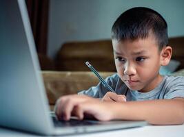 Technology studying at home using laptop computer, Student distance learning virtual distance online class on call virtual lesson, Parent or tutor teaching child boy with remote education. photo