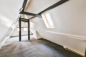 An attic with a ladder and a window photo