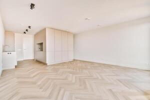 An empty room with white walls and wooden floors photo