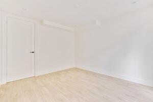 An empty room with white walls and wooden floors photo
