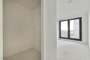 An empty room with white walls and a window photo