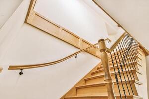 A wooden staircase with a handrail and railings photo