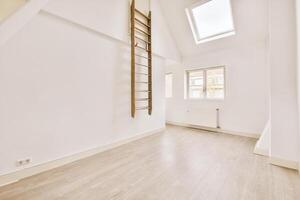 A ladder in an empty room with a window photo