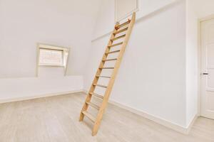 A ladder in an empty room with a window photo