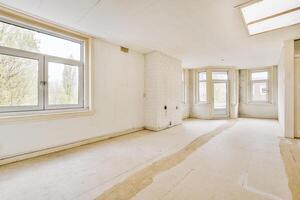 An empty room with a large window and a lot of white walls photo