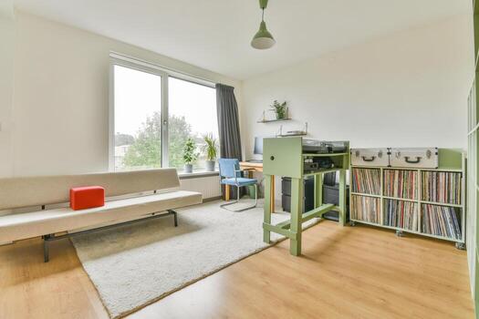 A room with a couch, a table, a record player and a window photo