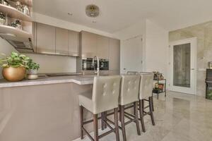 A kitchen with a bar and chairs in it photo