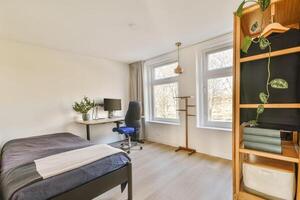A bedroom with a bed, desk and window photo