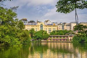 Hanoi, Vietnam - 26 June 2024 Hoan Kiem lake or Sword lake, Ho Guom in Hanoi, Vietnam with Turtle Tower, on clear day with blue sky and white clouds photo