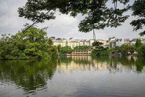 Hanoi, Vietnam - 26 June 2024 Hoan Kiem lake or Sword lake, Ho Guom in Hanoi, Vietnam with Turtle Tower, on clear day with blue sky and white clouds photo